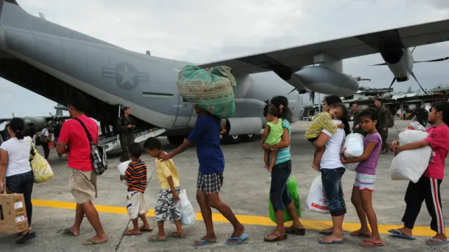 Sobrevivientes hacen fila para ser trasladados en avión a Manila