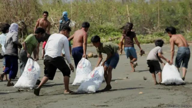 ساکنان روستایی در کاپیز کمک‌های ارسالی را به محل سکونت خود می‌برند. توفان هاینان یکی از شدیدترین توفان‌های تاریخ بوده است.