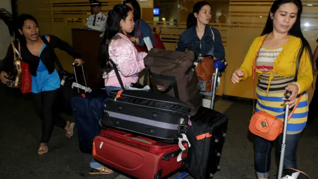 فلپائن سے تعلق رکھنے والی خواتین اپنے ملک واپس پہنچنے پر امیگریشن سے گزرنے کے انتظار میں ہیں۔