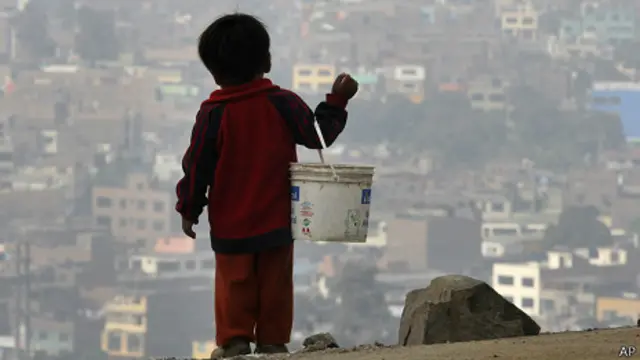 Chico con balde mirando tugurio