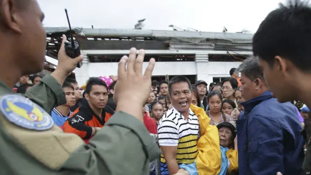 Petugas menahan warga yang ingin naik pesawat militer