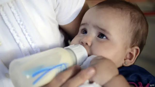 बच्चे को बोतल से दूध पिलाती माँ