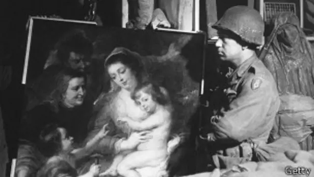 Американский солдат смотрит на бесценное полотно, найденное в мае 1945 года в Германии