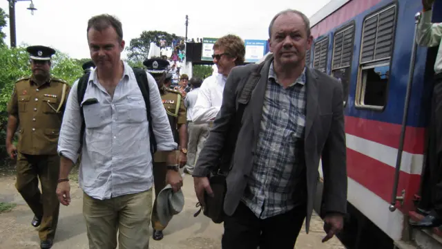 දුම්රියෙන් බස පොලිස් ආරක්ෂාව මධ්යයේ ආපසු යන මාධ්යවේදීන් කණ්ඩායම