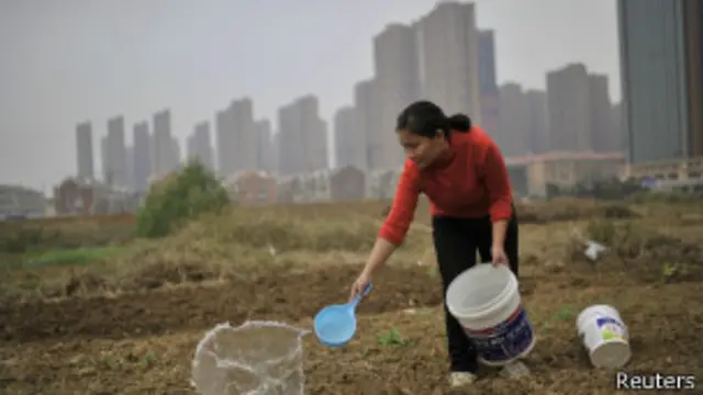 安徽农民浇地和远处高楼