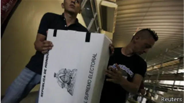 Dos hombres transportan urnas