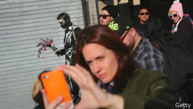 Женщина фотографирует себя на камеру смартфона в Нью-Йорке