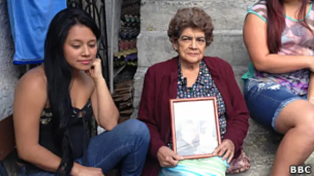 Franquelina Guerra con sus nietas en el barrio Pablo Escobar. En las rodillas, una foto de Pablo Escobar.