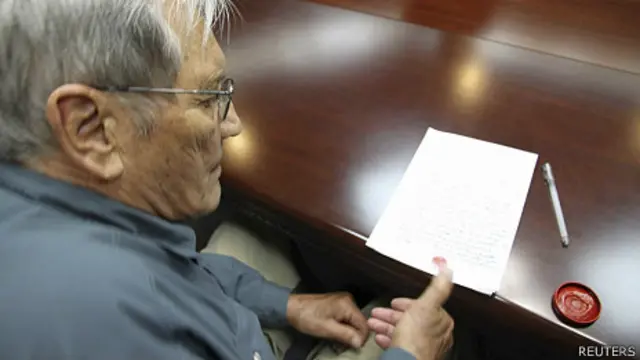 美國老兵美林•E•紐曼在朝鮮某不明地點於「謝罪書」上打指紋（朝中社2013年11月30日發放照片）