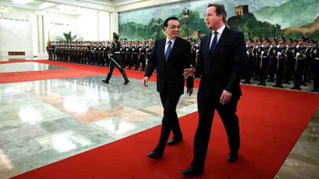 李克强去年12月欢迎到访的卡梅伦。卡梅伦是在坐了一年多的“冷板凳”后才实现北京之行的。