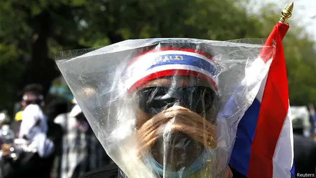 आंसू गैस से बचने के लिए प्लास्टिक ओढ़े एक प्रदर्शनकारी