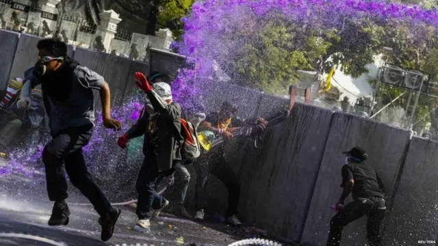 Cảnh sát chống bạo động dùng vòi rồng và hơi cay với người biểu tình, sau khi phe chống chính phủ cố gắng vượt qua hàng rào để vào các tòa nhà chính phủ.