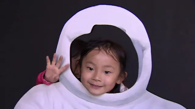 Niña china en exposición sobre la Luna