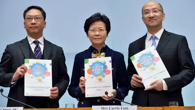 香港政务司司长林郑月娥（中）与官员展示第一阶段政改咨询文件（香港政府新闻处图片4/12/2013）