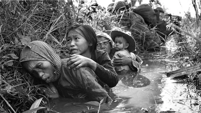 ویت کونگ کی جانب سے شدید فائرنگ سے بچنے کے لیے شہریوں نے ایک نہر میں پناہ لی ہوئی ہے۔ 