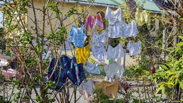 ملابس أطفال معلقة كي تجف على سور في مخيم للنساء في تاكلوبان.
