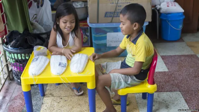 طفلان يستخدمان شفرات في تقطيع الشموع لبيعها.