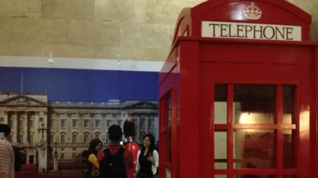 Kerajaan Inggris menampilkan replika kotak telepon umum merah dan poster Istana Buckingham.