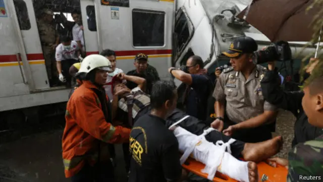 Petugas menyelamatkan korban luka-luka dari gerbong komuter line.