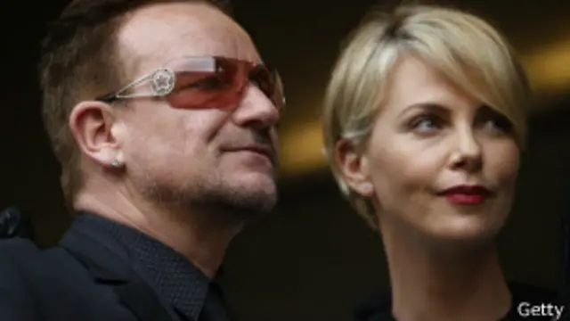 چارلیز ترون، هنرپیشه، و بونو، خواننده و کنشگر، در مراسم یادبود ماندلا