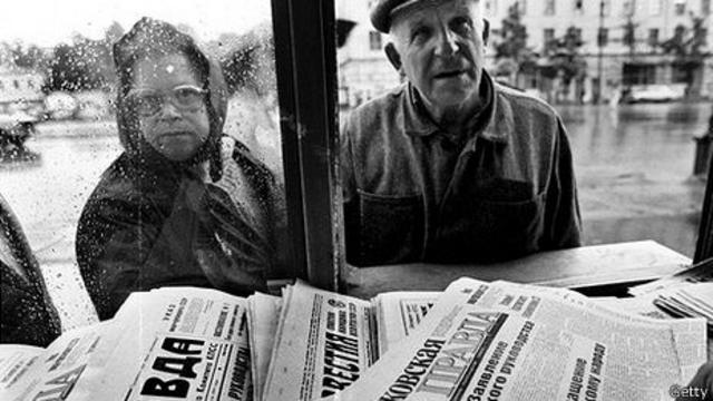 Hombre y mujer miran periódicos