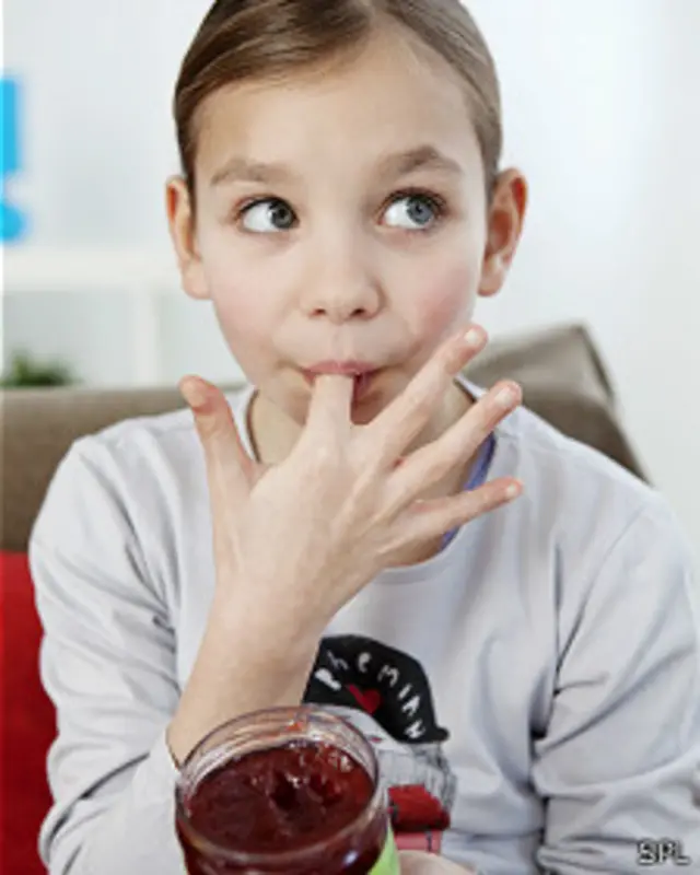 Niña probando mermelada