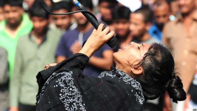 عبدالقادر ملا کو پھانسی دینے کے حق میں جمع لوگوں میں ایک خاتون نعرہ لگاتے ہوئے۔