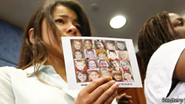 Una mujer muestra la imagen de los niños que murieron en Newtown