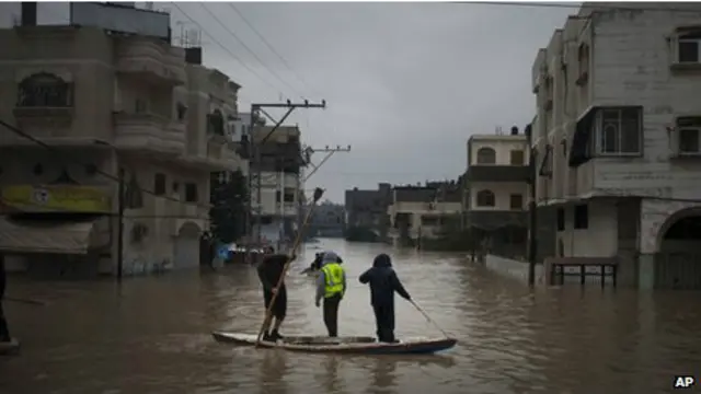 Tim penyelamat menggunakan perahu mengevakuasi korban dari genangan banjir.