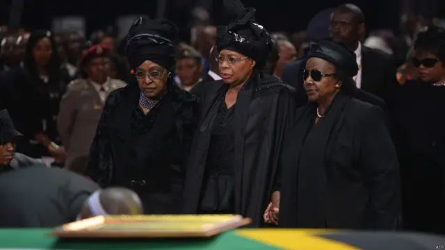 زوجة نيلسون مانديلا السابقة ، ويني مانديلا ماديكيزيلا، وأرملته غراسا ماشيل، تجلسان بجانب نعشه خلال مراسم الجنازة.