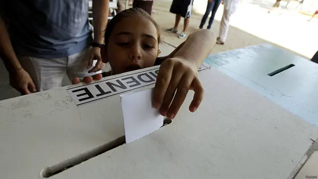 Niña deposita voto