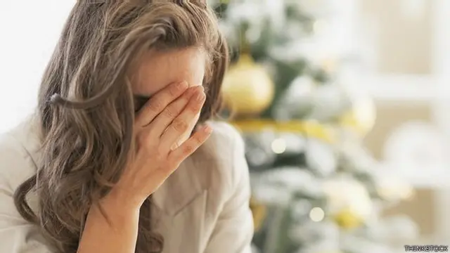 Mujer con la cara tapada y un árbol al fondo.