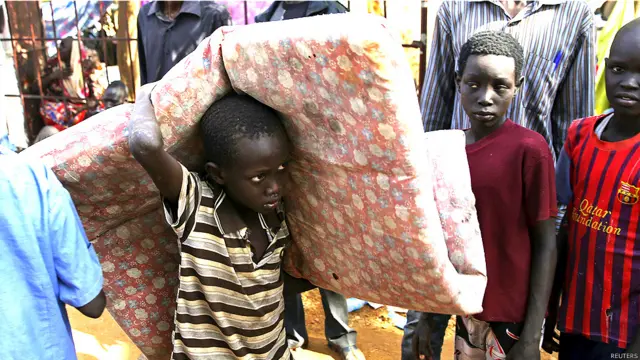 Niño ingresando con sus pocas posesiones, cargando un colchón, a un refugio de la ONU en Yuba, capital de Sudán del Sur
