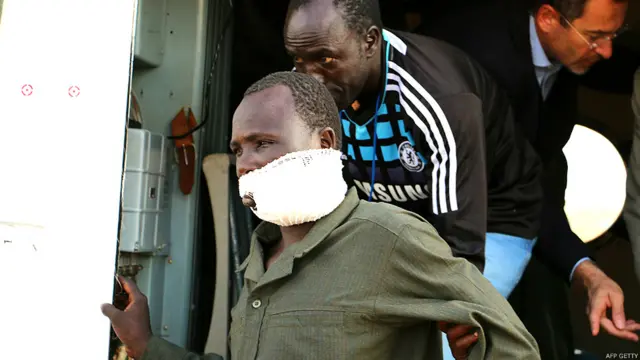 Un hombre con un vendaje que le cubre la boca desciende de un transporte aéreo de la ONU que lo evacuó desde Bor a Yuba