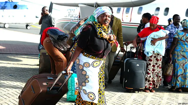 Una mujer que huyó de Sudán del Sur carga su valija luego de regresar a su país, Kenia