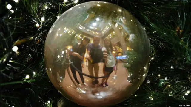 ایلکس ہائنز: ’سنگاپور میں ایک کرسمس ٹری کی سجاوٹ میں فیملی کے عکس کی تصویر۔‘