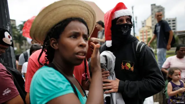 В Сан-Паулу представник Чорного блоку роздає одяг бідним. Анархісти в масках застосовували насилля, щоб донести свої антикапіталістичні послання на акціях протесту, що сколихнули Бразилію цього року. 