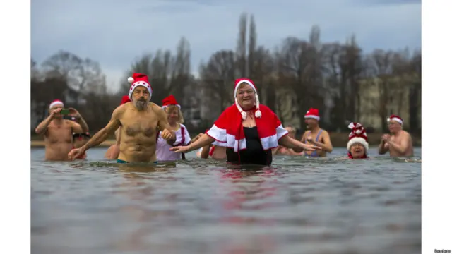 أعضاء في نادي "برلين سيلز" يمارسون السباحة خلال احتفالات تقليدية بعيد الميلاد في برلين، ألمانيا. 