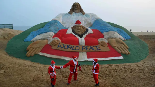 أطفال في الهند بالقرب من تمثال يجسد المسيح أقيم على شاطئ غولدن سي في مدينة بوري يوم الأربعاء 24 ديسمبر/كانون الأول