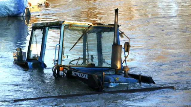 दक्षिणी ब्रिटेन, बाढ़ के कारण प्रभावित लोग, भविष्य में तेज़ हवा, बारिश और आँधी की पर्यावरण एजेंसी ने जताई आशंका, पानी में डूबी गाड़िुयां, बाढ़ में घरों से सामान निकालते लोग, बाढ़ से प्रभावित जनजीवन,
