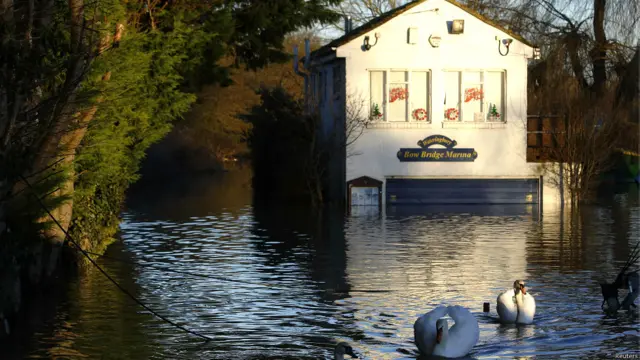 दक्षिणी ब्रिटेन, बाढ़ के कारण प्रभावित लोग, भविष्य में तेज़ हवा, बारिश और आँधी की पर्यावरण एजेंसी ने जताई आशंका, पानी में डूबी गाड़िुयां, बाढ़ में घरों से सामान निकालते लोग, बाढ़ से प्रभावित जनजीवन,