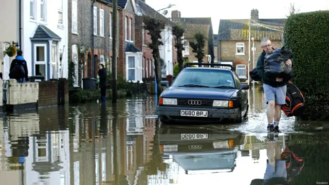 दक्षिणी ब्रिटेन, बाढ़ के कारण प्रभावित लोग, भविष्य में तेज़ हवा, बारिश और आँधी की पर्यावरण एजेंसी ने जताई आशंका, पानी में डूबी गाड़िुयां, बाढ़ में घरों से सामान निकालते लोग, बाढ़ से प्रभावित जनजीवन,