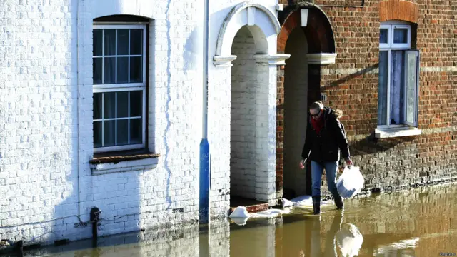 दक्षिणी ब्रिटेन, बाढ़ के कारण प्रभावित लोग, भविष्य में तेज़ हवा, बारिश और आँधी की पर्यावरण एजेंसी ने जताई आशंका, पानी में डूबी गाड़िुयां, बाढ़ में घरों से सामान निकालते लोग, बाढ़ से प्रभावित जनजीवन,