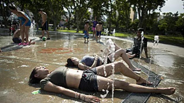Meninas se refrescam em chafariz em Buenos Aires