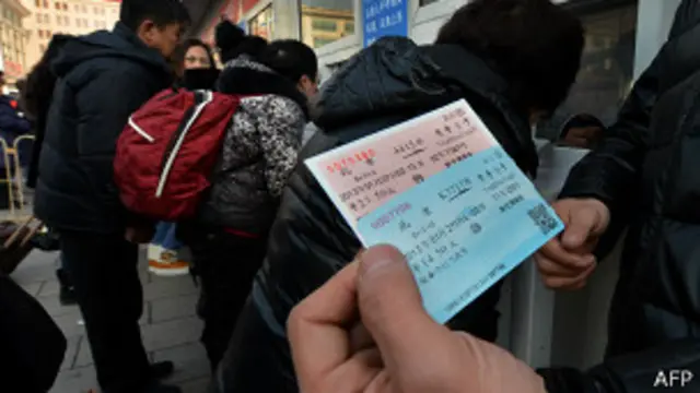 北京火车站外一名市民手持春运期间车票（26/1/2013）