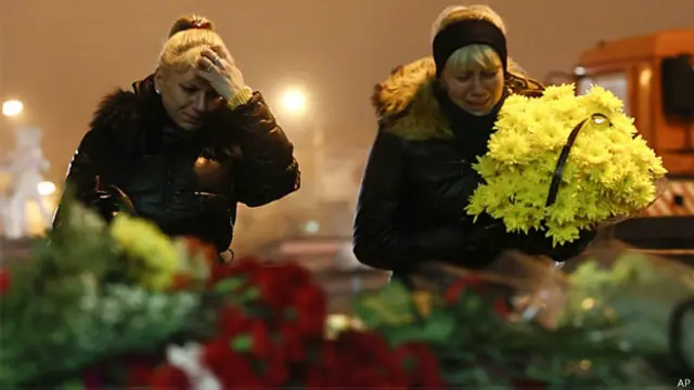 Russas choram e depositam flores em frente à estação de trem de Volgogrado (AP)