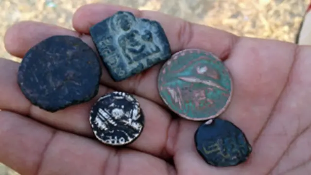 مہماتما بدھ کی مورتیاں اور مختلف ادوار کے سکے موجود ہیں جن میں چاندی اور سونے، اشوکا دور کے سکے بھی موجود ہیں: سکے فروخت کرنے والا ایک شخص