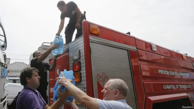 Bombeiros distribuem água para minimizar calor em Buenos Aires, na segunda-feira (Reuters)