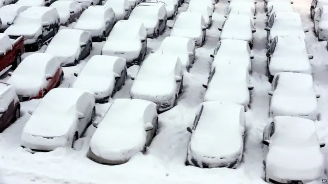 شکاگو کے ہوائی اڈے پر کھڑی گاڑیوں پر برف کی دبیز تہہ جمی ہوئی ہے۔