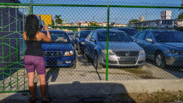Mujer cubana fotografiando autos nuevos